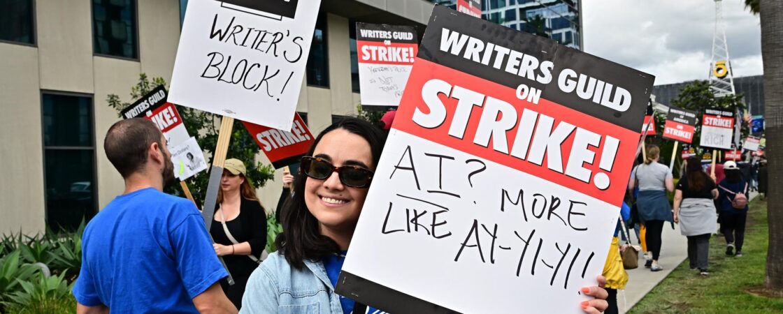 Ilustracja przedstawia strajkujących scenarzystów w Stanach Zjednoczonych domagających się podwyżek