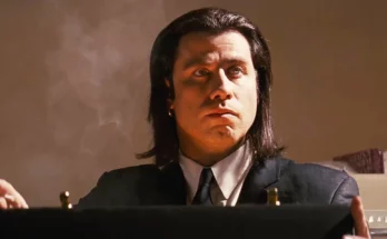 John Travolta w filmie Pulp Fiction (1994) jako Vincent Vega ze świecąca aktówką